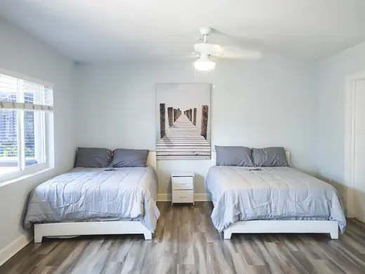 Cozy bedroom with two beds at Amity Palm Beach detox center in Miami.