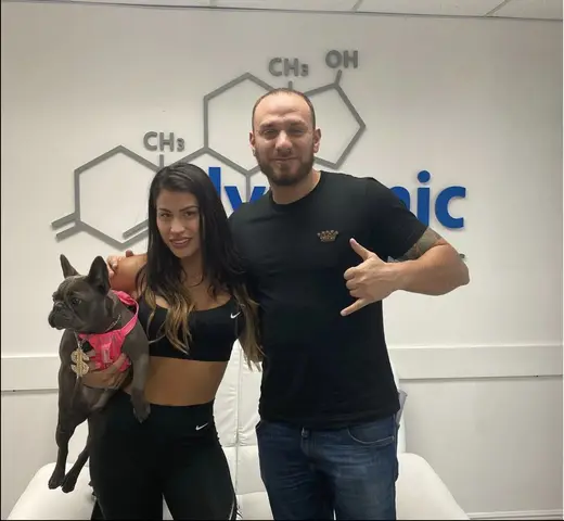 Woman holding a dog with a man in a modern office at Dynamic Wellness detox center in Miami.