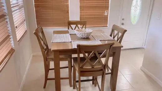 Bright dining area with wooden table at South Florida Oasis, a sober living home in Miami.