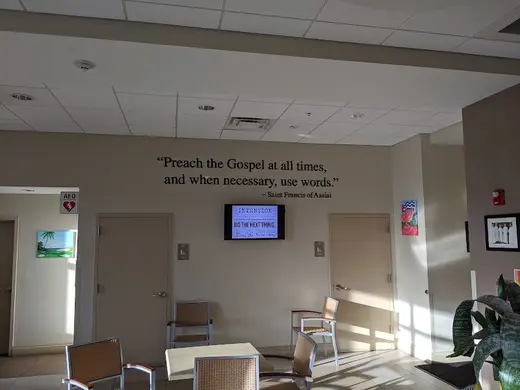 Welcoming common area with inspirational quote at Camillus House, a sober living home in Miami.