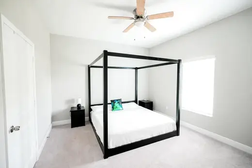 Cozy bedroom with four-poster bed at Rocklay Sober Living Homes, a sober living home in Miami.