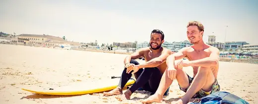 Two men relaxing on the beach near Recovery House 54 Sober Living Home in Miami.
