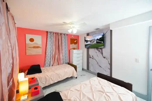 Cozy bedroom with two beds at Ave Fenix ALF Recovery House, a sober living home in Miami.