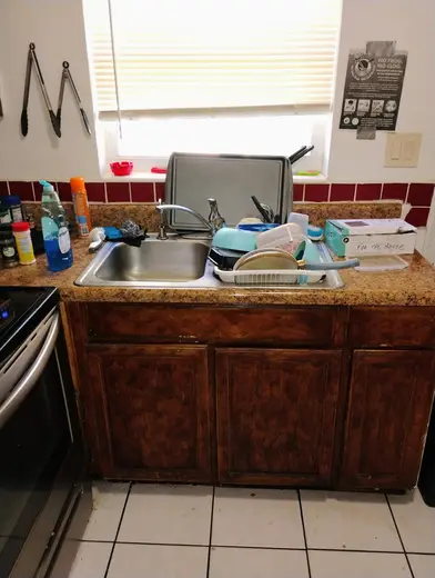 Cluttered kitchen sink area at Project SOAR Recovery Residences, a sober living home in Miami.