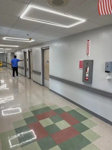 Brightly lit hallway with patient rooms at Azure Shores Rehab, a treatment center in Miami.