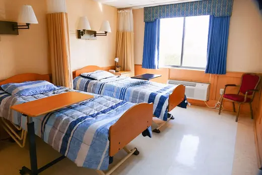 Cozy bedroom with two beds at Palmetto Care Center, a treatment center in Miami.